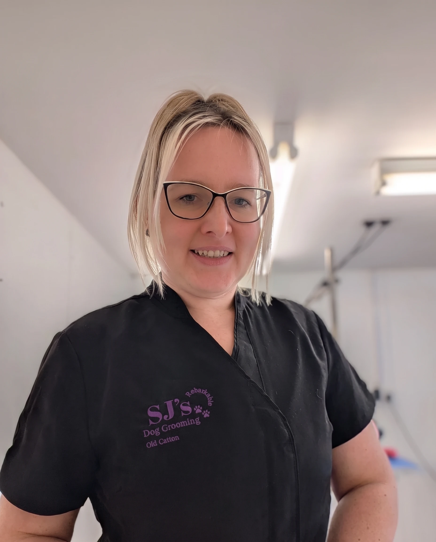 Sarah smiling in her SJ’s Rebarkable uniform in the salon